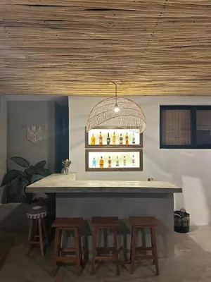 a bar with stools around it with a light fixture at Kaia Beach Lodge en Cosón in Las Terrenas