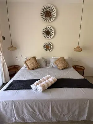 a bedroom with a large white bed with two mirrors at Kaia Beach Lodge en Cosón in Las Terrenas