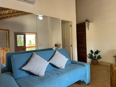 a blue couch with two pillows on it in a living room at Palmeras in Las Galeras