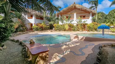 a house with a swimming pool in front of a house at Palmeras in Las Galeras
