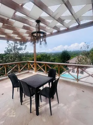a black dining table and chairs on a balcony at Villa para grupos in Concepción de La Vega