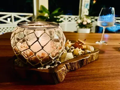 a glass vase on a wooden table with a wine glass at Las Terrenas La Dolce Vita 7, Captivating and Exciting in Las Terrenas