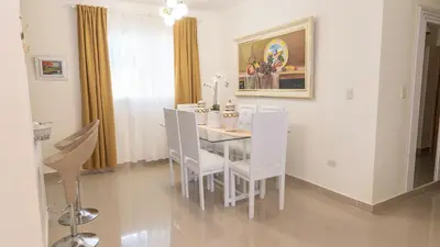 a dining room with a white table and chairs at Agua Azul Boca Chica Accommodation in Andrés