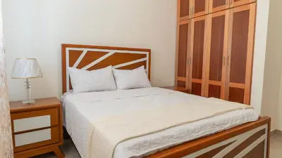 a bedroom with a bed with a wooden headboard at Agua Azul Boca Chica Accommodation in Andrés
