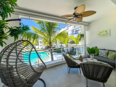 a living room with a ceiling fan and a large window at Dimary Charming Apt, 5 Pools, Walk to the Beach Dominicus Bayahibe la Romana in La Laguna