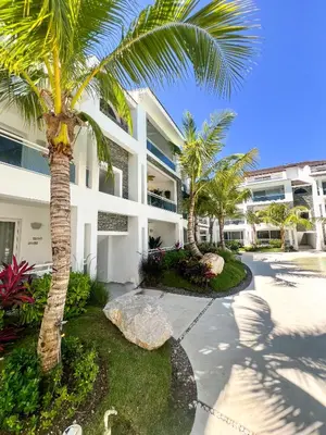 a palm tree in front of a building at Dimary Charming Apt, 5 Pools, Walk to the Beach Dominicus Bayahibe la Romana in La Laguna