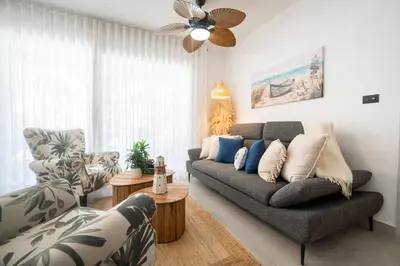 a living room with a couch and a fan at Dimary Charming Apt, 5 Pools, Walk to the Beach Dominicus Bayahibe la Romana in La Laguna