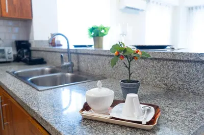 a kitchen counter with a sink and a tray with a tea set at Apartment in Santo Domingo in Santo Domingo