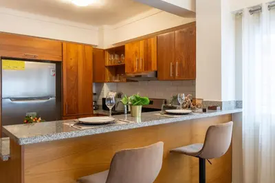 a kitchen with a bar with two chairs and a counter top at Apartment in Santo Domingo in Santo Domingo