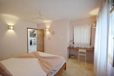a bedroom with a large bed and a kitchen at House with pool 300 m from Las Ballenas beach in Las Terrenas