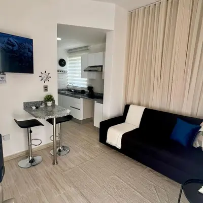 a living room with a black couch and a table at Maple Beach, apartamento en Punta Cana in Punta Cana
