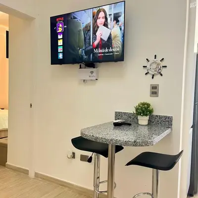 a room with a table and a tv on the wall at Maple Beach, apartamento en Punta Cana in Punta Cana