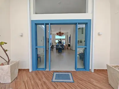 a hallway with a blue door and a living room at Luxury Oceanfront Villa with Heated Pool, Jacuzzi, AC, BBQ, Starlink Wi-Fi, Chef's Kitchen, Staff Included, Mountain Views, Near El Quemaito, San Rafael, and Los Patos Beach in Santa Cruz de Barahona