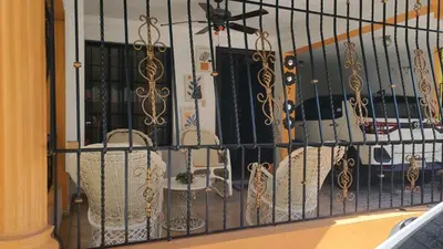 a wrought iron fence with a dog on a balcony at My hogar in Colorado