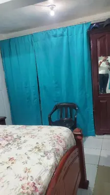 a bedroom with a bed and a blue curtain at My hogar in Colorado
