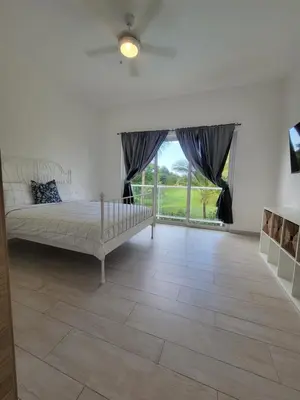 a bedroom with a bed and a large window at Modern 2BDR - Pool & Golf View in Punta Cana