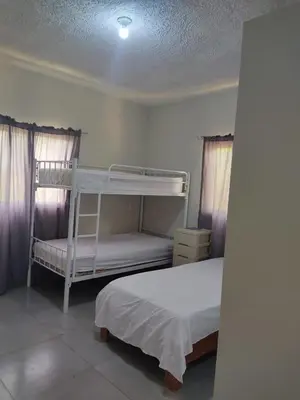 a bedroom with two bunk beds and purple curtains at Hermosa Casa en Juana Vicenta Samana in Santa Bárbara de Samaná