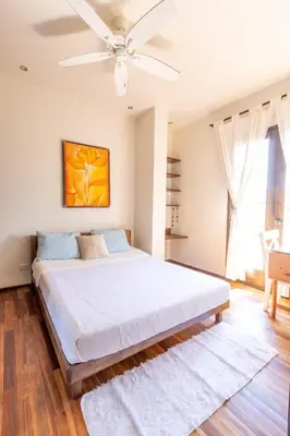 a bedroom with a large bed with a ceiling fan at Casa De Mabel in Santo Domingo