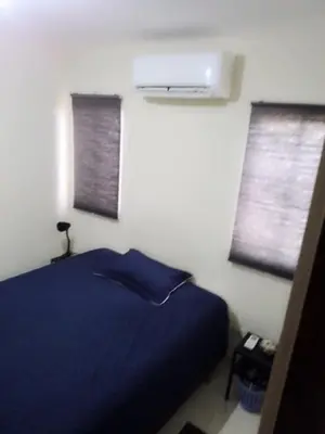 a bedroom with a blue bed and two windows at Hermoso Apartamento Turístico in Colorado