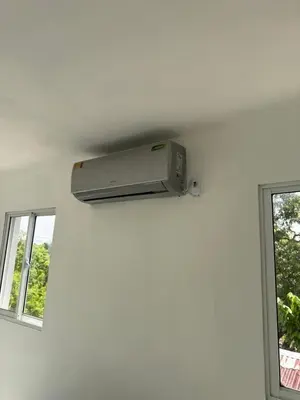 a wall mounted air conditioner in a room with two windows at Aparta Estudio Disponible
