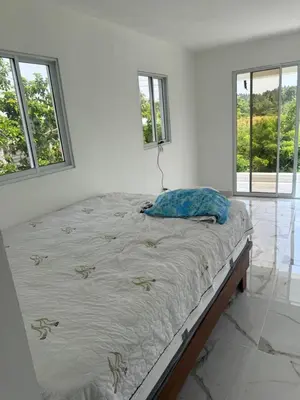 a bed in a white room with windows at Aparta Estudio Disponible
