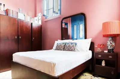a bedroom with pink walls and a bed with a mirror at Stylish Colonial Townhouse in Santo Domingo's Historic Heart in Santo Domingo