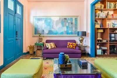 a living room with a purple couch and a painting at Stylish Colonial Townhouse in Santo Domingo's Historic Heart in Santo Domingo