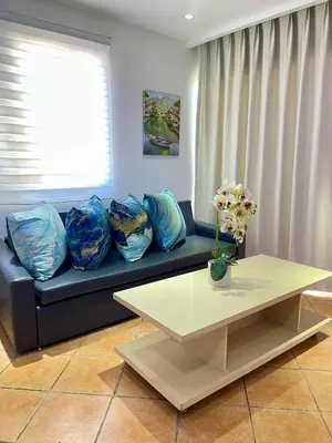 a living room with a blue couch and a table at Juan Dolio paradise in Villas del Mar
