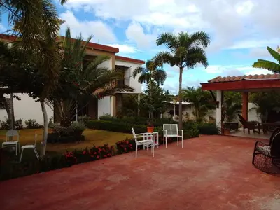 a patio of a house with chairs and palm trees at Villa Dupi in Colorado