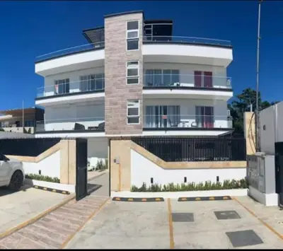 a large white building with a parking lot at Beach and comfort in Las Terrenas