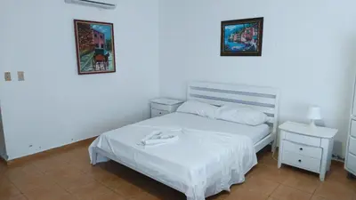 a bedroom with a white bed and two night stands at Appartamento Albatros, Juan Dolio in Juan Dolio