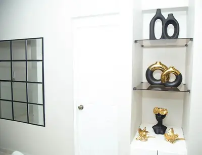 a room with a white door and a shelf with a mirror at Luxury 2 bedroom Apartment in Santiago de los Caballeros