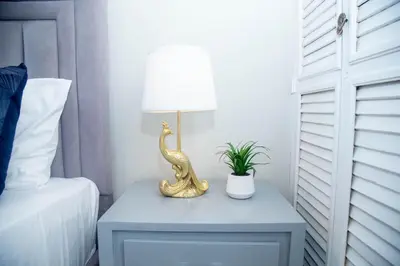 a table with a lamp on it next to a bed at Luxury 2 bedroom Apartment in Santiago de los Caballeros