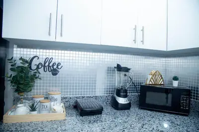 a kitchen counter with a coffee maker and a microwave at Luxury 2 bedroom Apartment in Santiago de los Caballeros