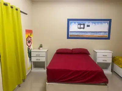 a bedroom with a red bed and yellow curtains at Villa Hotel Saul & Lucas in Castillo