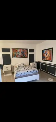a bedroom with a bed and paintings on the wall at Villa Hotel Saul & Lucas in Castillo