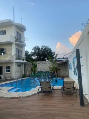 a swimming pool with two chairs next to a building at Villa Hotel Saul & Lucas in Castillo