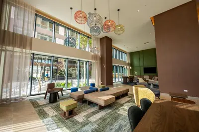 a large lobby with couches and chairs and windows at Hotel Hampton By Hilton Santiago De Los Caballeros in Santiago de los Caballeros