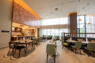 a restaurant with tables and chairs in a room at Hotel Hampton By Hilton Santiago De Los Caballeros in Santiago de los Caballeros