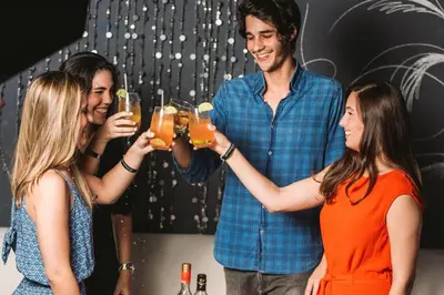 a group of people holding up glasses of beer at Emotions by Hodelpa - Juan Dolio in Juan Dolio