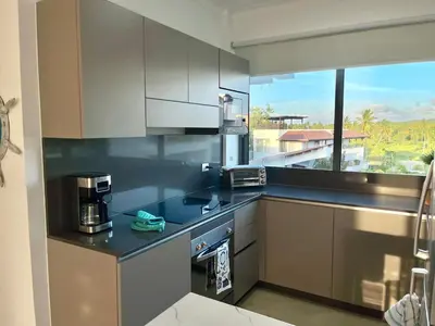 a kitchen with stainless steel appliances and a large window at Upper-Level Penthouse, Beachfront Residence in Las Terrenas