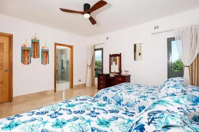 a bedroom with a bed and a ceiling fan at Upper-Level Penthouse, Beachfront Residence in Las Terrenas
