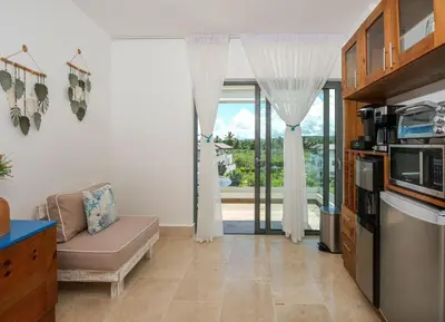 a living room with a couch and a large window at Upper-Level Penthouse, Beachfront Residence in Las Terrenas