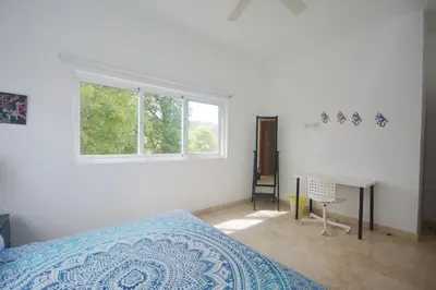 a bedroom with a bed and a desk and a window at Beautiful apartment with sea view in Las Terrenas