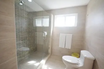 a bathroom with a toilet and a glass shower at Beautiful apartment with sea view in Las Terrenas