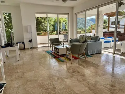 a living room with a couch and chairs and windows at Beautiful apartment with sea view in Las Terrenas