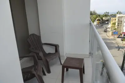 a pair of chairs and a stool on a balcony at Relaxing Ocean View Getaway in Boca Chica501 in Boca Chica