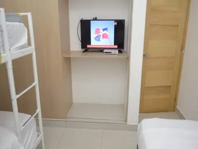 a room with a bed and a television on a shelf at Relaxing Ocean View Getaway in Boca Chica501 in Boca Chica