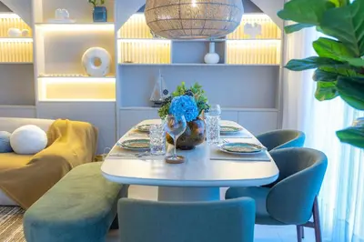 a table with blue chairs and a white table with flowers at Xanadú in Sampiño
