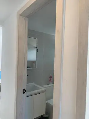 a white bathroom with a sink and a toilet at Prado Suites Luxurious Apartment for Long Term Stay in Las Terrenas